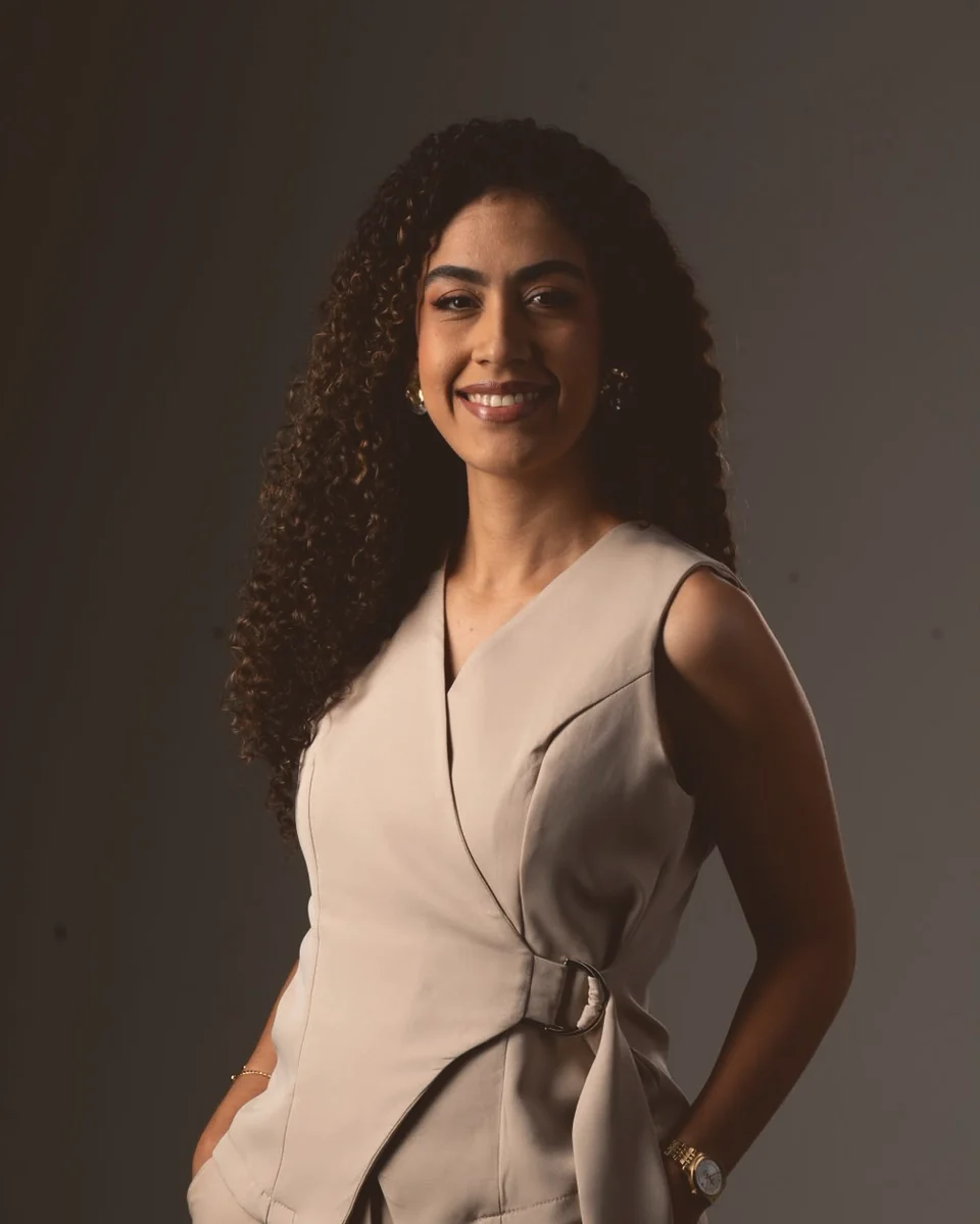 Retrato da psicóloga Karolina Oliveira, sorrindo, com conjunto bege